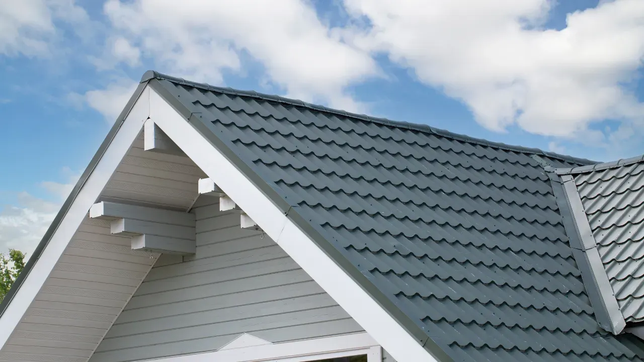 Gray shingle roofing with white trim against a cloudy sky.